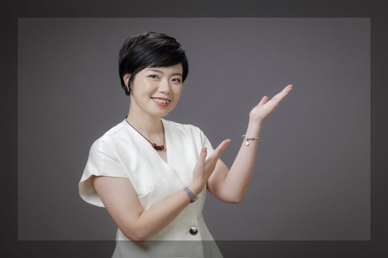 Ngô Huyền Trang áo trắng, tay giơ chào, nền xám