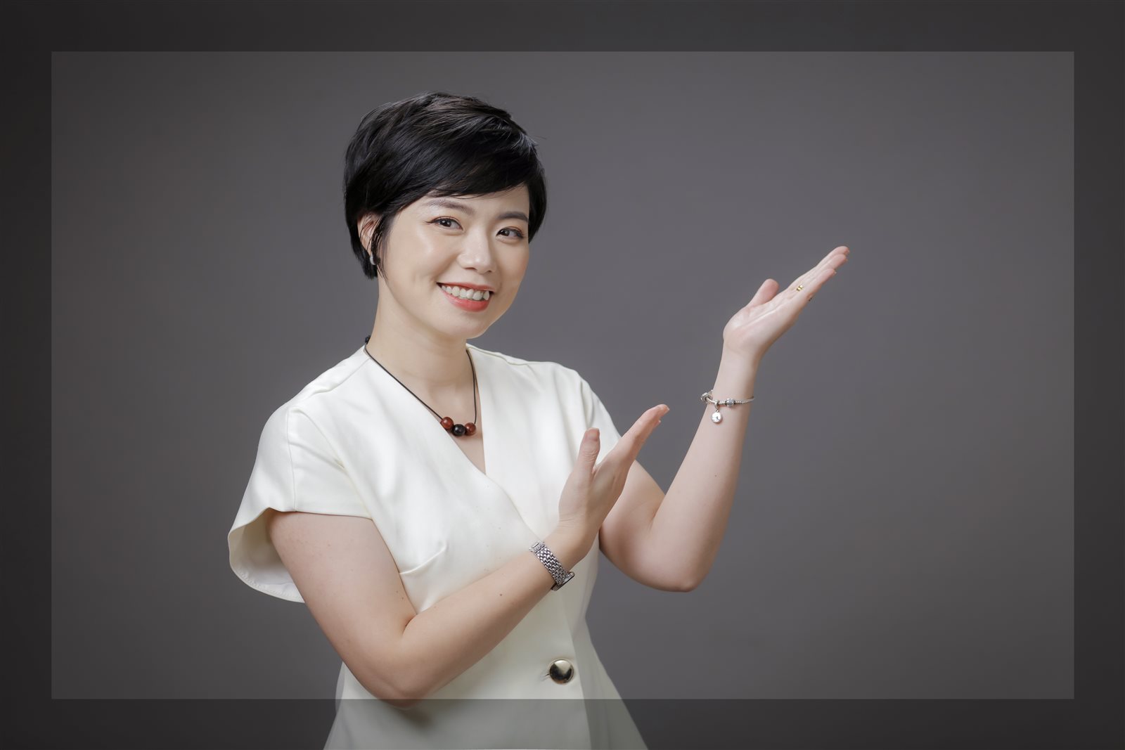 Ngô Huyền Trang áo trắng, tay giơ chào, nền xám