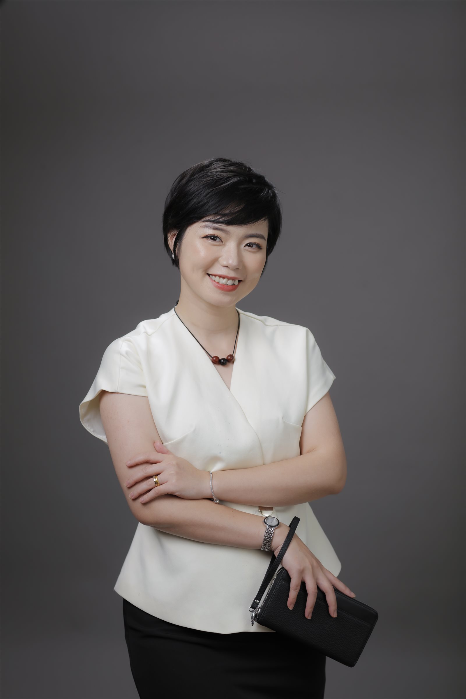 Ngô Huyền Trang áo trắng, dáng đứng, nền xám